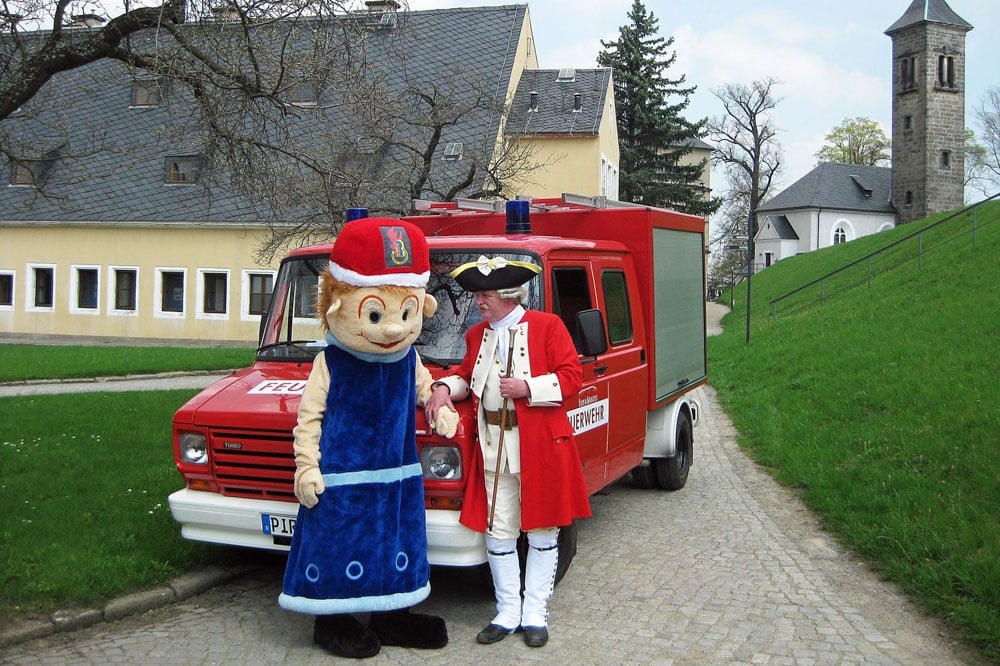 Löschi und Schließkapitän Clemens vor dem Löschfahrzeug der Festungsfeuerwehr. Foto: Festung Königstein gGmbH