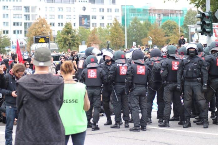 Angespannte Partystimmung. Die Polizei rückt zur Räumung vor. Dahinter unterhalten sich Menschen über ihre Stadt. Foto: Michael Freitag