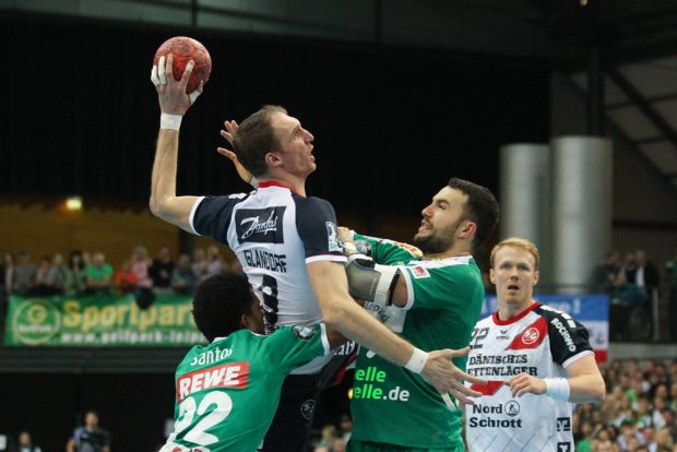 Raul Santos und Bastian Roscheck (beide DHfK) mit vereinten Kräften gegen Holger Glandorf. Foto: Jan Kaefer