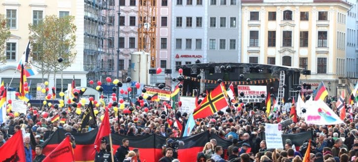 Die Deutschlandfahne als optische Mauer gegen die Gegendemonstranten bei Pegida. Foto: L-IZ.de