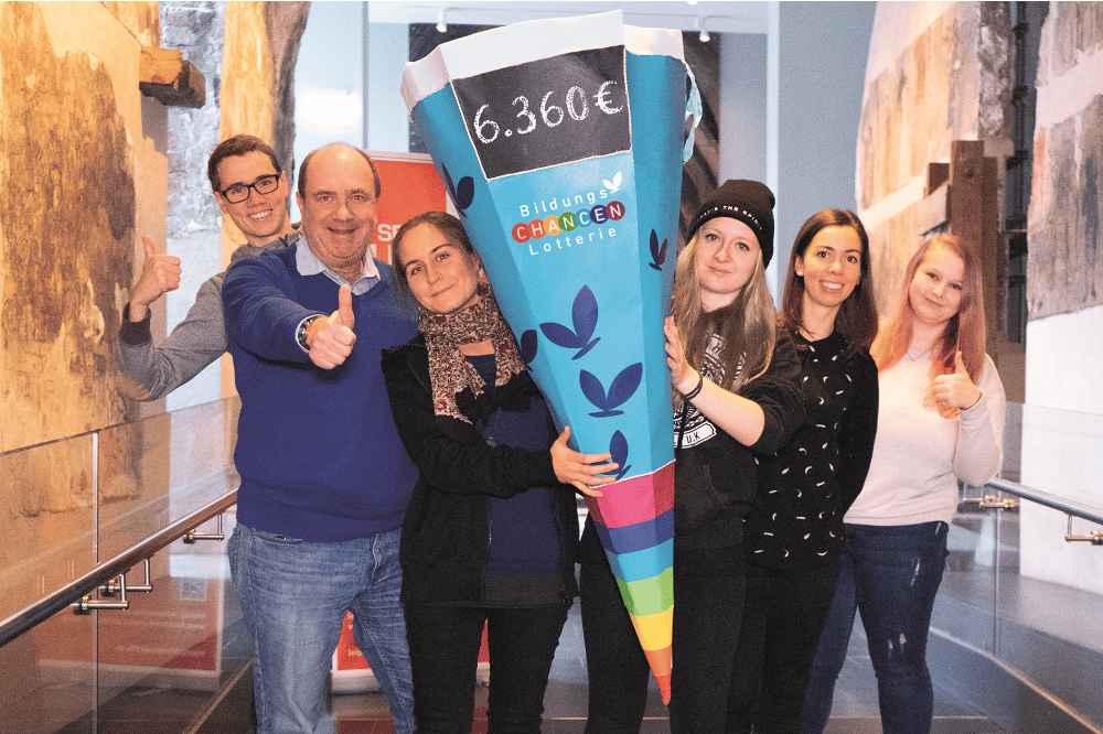 Die Bildungs-Chancen-Lotterie überreicht ihre Schultüte als Symbol für Bildungsförderung. Zu sehen sind Achim Schütz, Pressesprecher Bildungs-Chancen-Lotterie (2.v.r.), Laura Lässig (3.v.l.) und Victoria Henning (3.v.r.) als Vorsitzende von ROCK YOUR LIFE! sowie Mentoren der Universität Leipzig. Foto: Nilu Poudyal