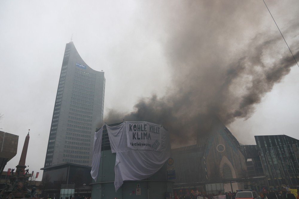 Robin Wood-Aktivisten mit einem simulierten Kohlemeiler auf dem Augustusplatz in Leipzig. Foto: Michael Freitag
