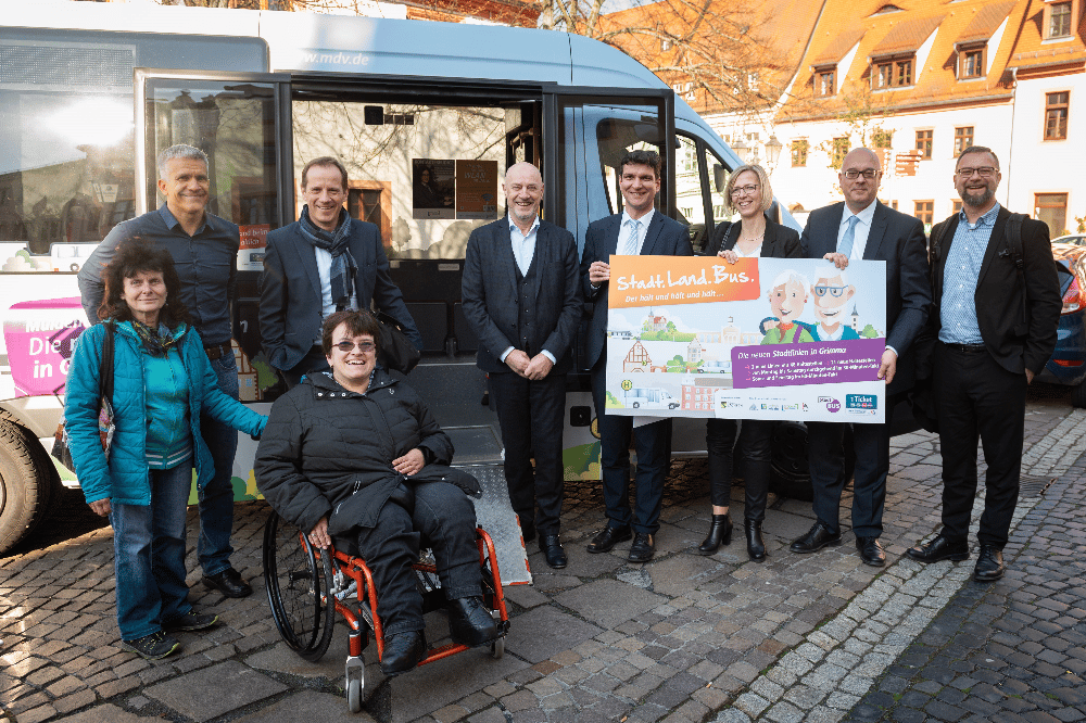 Jana Treffler mit Begleitung/ ÖPNV für alle (Vordergrund), (Hintergrund v.l.n.r.) Oberbürgermeister Matthias Berger/ Stadt Grimma, Steffen Lehmann/ Geschäftsführer MDV, Stadtrat Grimma, Landrat Henry Graichen/ Landkreis Leipzig, Ines Lüpfert/ 2. Beigeordnete Landkreis Leipzig, Andreas Kultscher/ Geschäftsführer Regionalbus Leipzig GmbH, Ron Böhme/ Bereichsleiter Verkehrsplanung MDV. Foto: Christian Modla/ Westend Communication für MDV