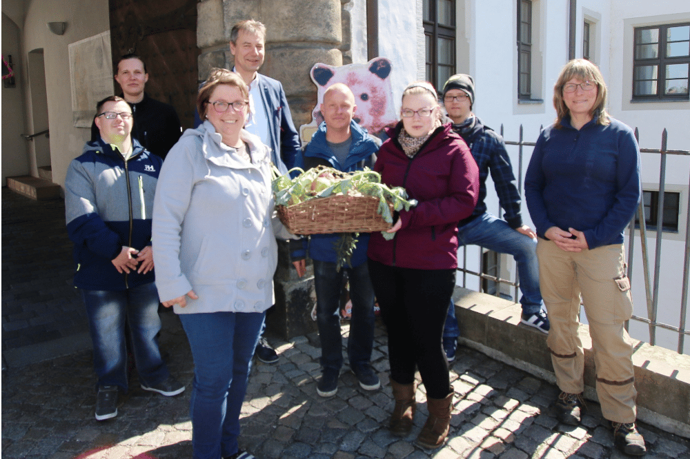 Vertreter der Behinderten-Werkstätten des Lebenshilfe-Vereins Torgau brachten Landrat Kai Emanuel und den Tierpflegerinnen des Landratsamtes Nordsachsen ein leckeres Geburtstagsgeschenk für Braunbärin Jette mit. Foto: Landratsamt/Stracke