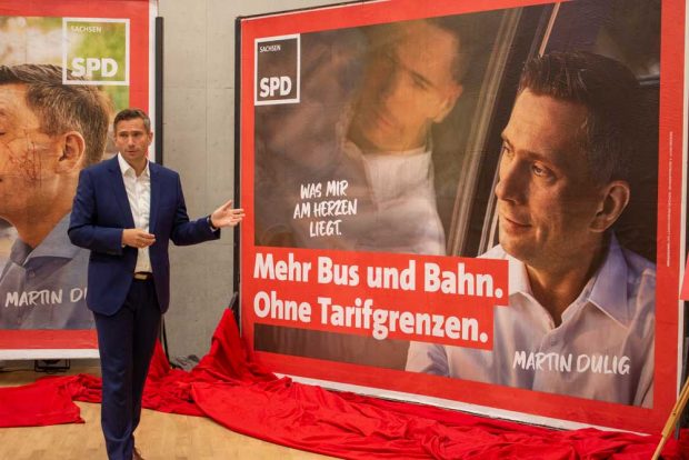 Martin Dulig mit dem Plakat "Mit Bus und Bahn. Ohne Tarifgrenzen". Foto: SPD Sachsen
