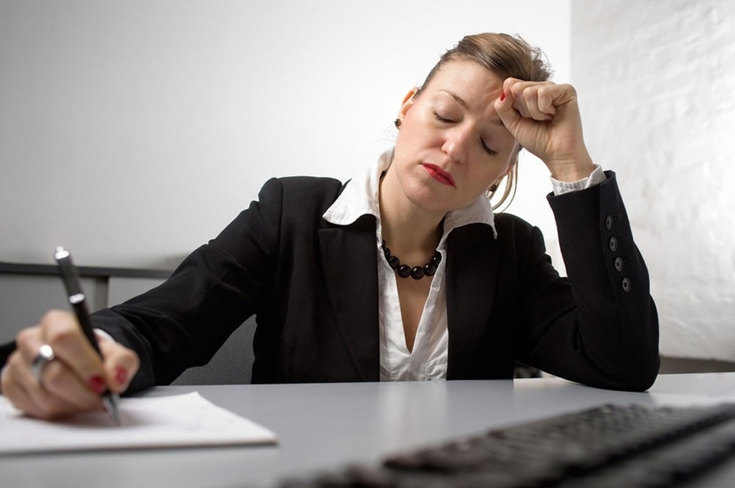 Müde Frau am Schreibtisch, Foto: BARMER
