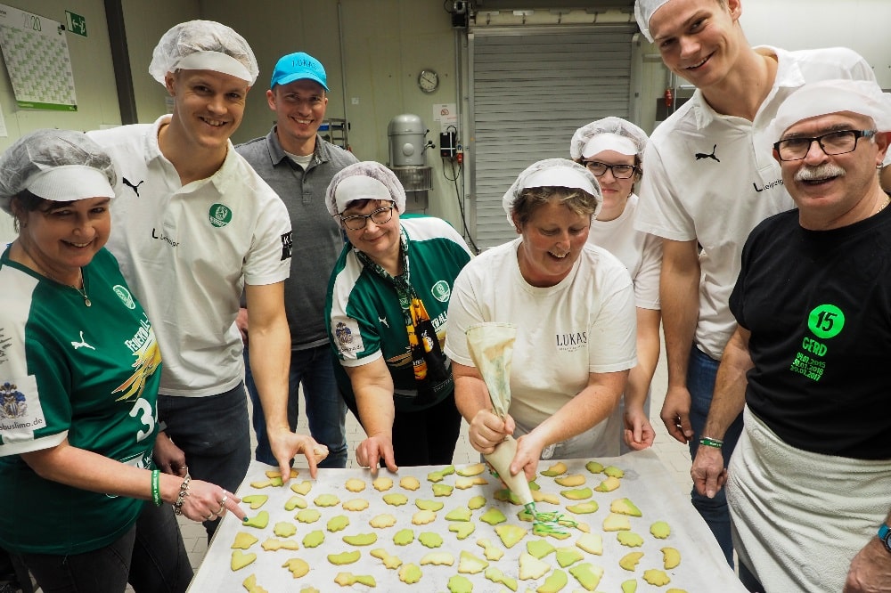 Niclas Pieczkowski und Julius Meyer-Siebert beim Plätzchen verzieren mit den Fans. Quelle: SC DHfK
