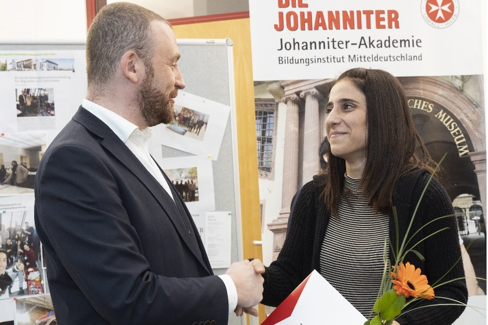 Lars Menzel überreicht Sozdar Mohammad ihr Zeugnis. Quelle: Johanniter/Sebastian Späthe