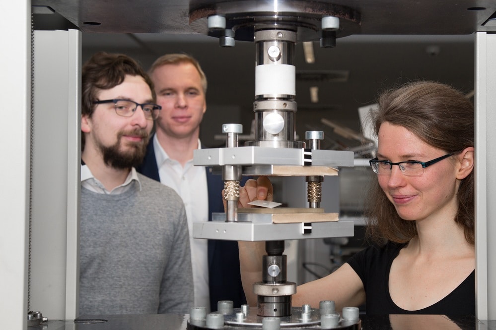 Nachwuchsgruppenleiter Florian Wallburg, Professor Stephan Schönfelder und Doktorandin Ulrike Käppeler (v.l.n.r.) an einer Prägemaschine im Werkstofflabor der HTWK Leipzig. Foto: HTWK Leipzig