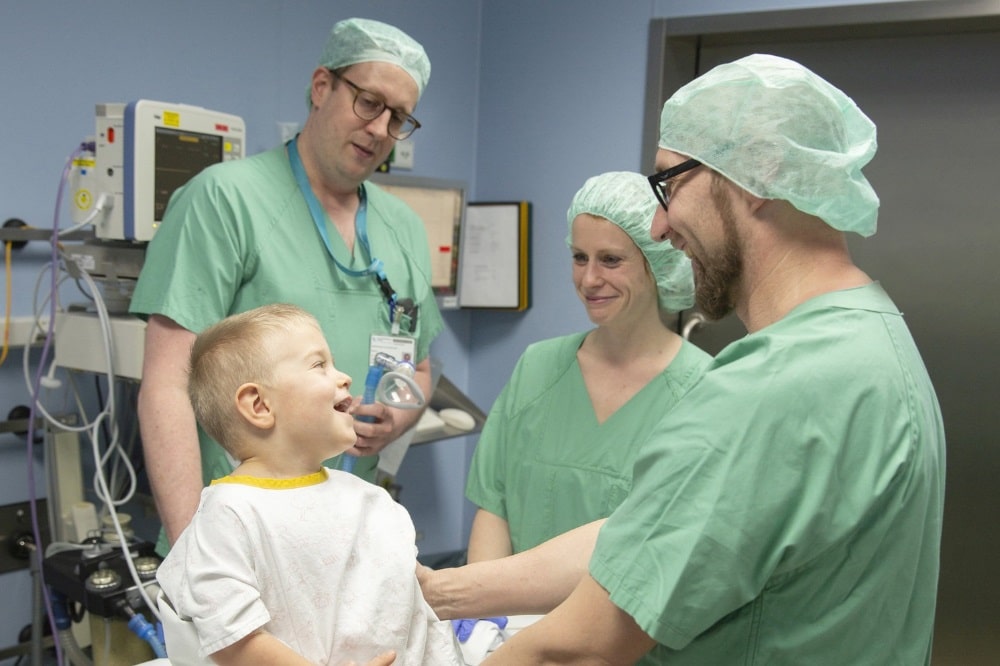 Auch der kleine Lenny ist viel entspannter vor seiner Operation, weil sein Papa (re.) dabei bleiben kann, bis er nach Narkoseeinleitung eingeschlafen sein wird. Das erleichtert dann die Arbeit der Anästhesisten Dr. Tobias Piegeler (hinten, li.), Geschäftsführender Oberarzt der Klinik und Poliklinik für Anästhesiologie und Intensivtherapie, und Julia Becker (hinten, re.), Fachärztin für Anästhesiologie. Foto: Stefan Straube / UKL