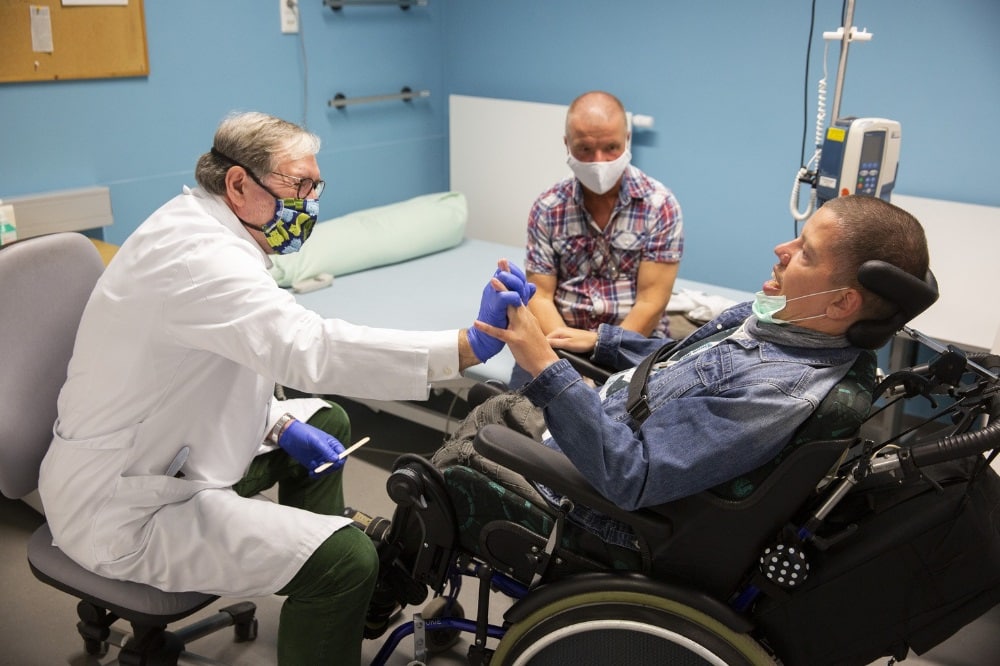 Dank eines Anrufs aus dem MZEB bei der Familie von Marcel Siebert (rechts) wurde ein dringendes Problem bei dem 36-Jährigen erkannt. Vor Ort am UKL konnte Oberarzt Wolfgang Köhler (li.) die Störung gezielt behandeln. Vater Uwe Siebert (hinten, Mi.) betreut seinen Sohn zusammen mit seiner Frau im Moment rund um die Uhr. Foto: Stefan Straube / UKL