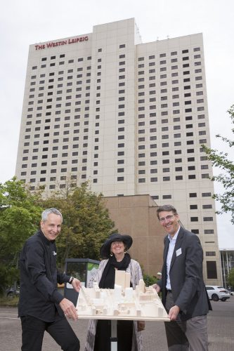 Prof. Jörg Springer, Dorothee Dubrau und Norman Weichhardt mit dem Siegermodell von HENN Architekten vor dem Westin Hotel. Foto: Covivio / Stefan Hoyer