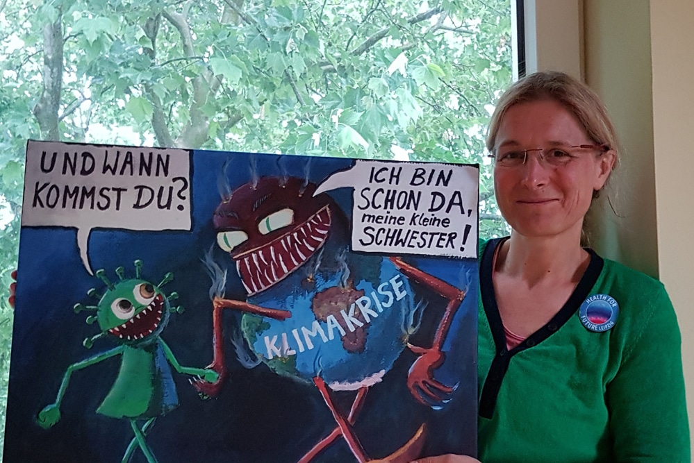 Melanie Gerhards mit einer Corona-Karikatur von Jörg Schwulst, die alles sagt. Foto: health for future Leipzig