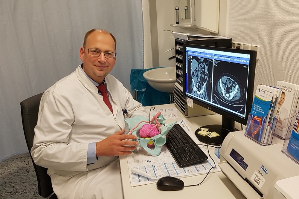 Privatdozent Dr. Boris Jansen-Winkeln, Stellvertretender Leiter des Bereichs Viszeralchirurgie am UKL, mit dem Modell eines Beckens mit dem Rezidivtumor (pink eingefärbt). Foto: UKL