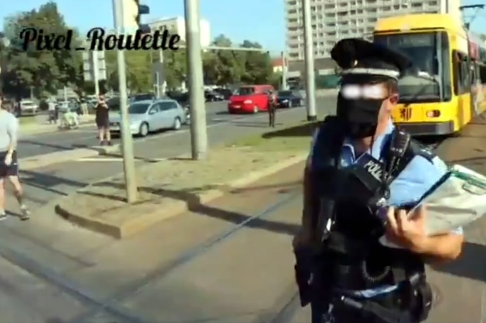 Ein Beamter in Dresden greift zur Pistole. Fotoscreen des Videos von @Pixel_Roulette (Twitter)