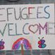 Schild mit Refugees welcome – Aufschrift.