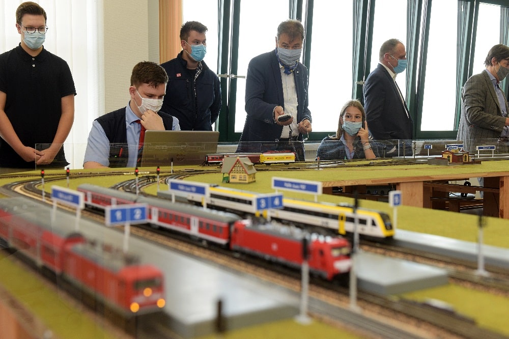 Landrat Kai Emanuel steuert einen Zug von Delitzsch nach Halle, nachdem die Auszubildende Saskia Wagenhaus (rechts daneben) die Strecke freigegeben hat. Foto: LRA/Bley