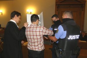 Justizbeamte nehmen dem Angeklagten Edris Z. (M.) zum Prozessbeginn am 7. Oktober die Handfesseln ab. Links sein Verteidiger Georg K. Rebentrost. Foto: Lucas Böhme