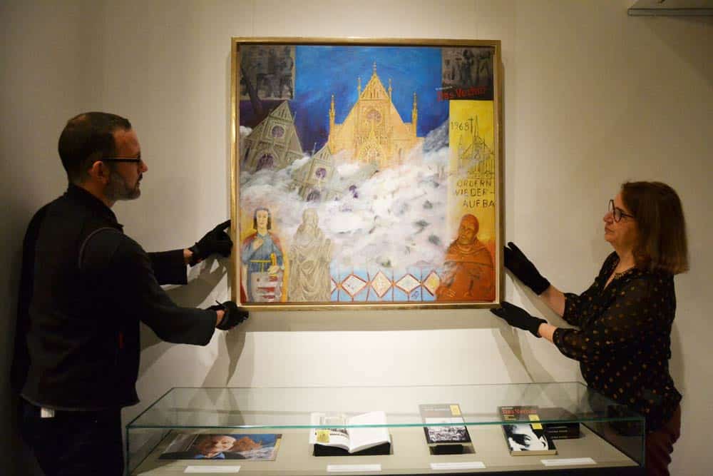 Ulrike Dura, Bereich Kunstsammlung des Stadtgeschichtlichen Museums, und Robert Brückner vom technischen Dienst des Museums, beim Einrichten der Präsentation des Ölgemäldes „Fall der Pauliner-Kirche“. Foto: Stadtgeschichtliches Museum Leipzig