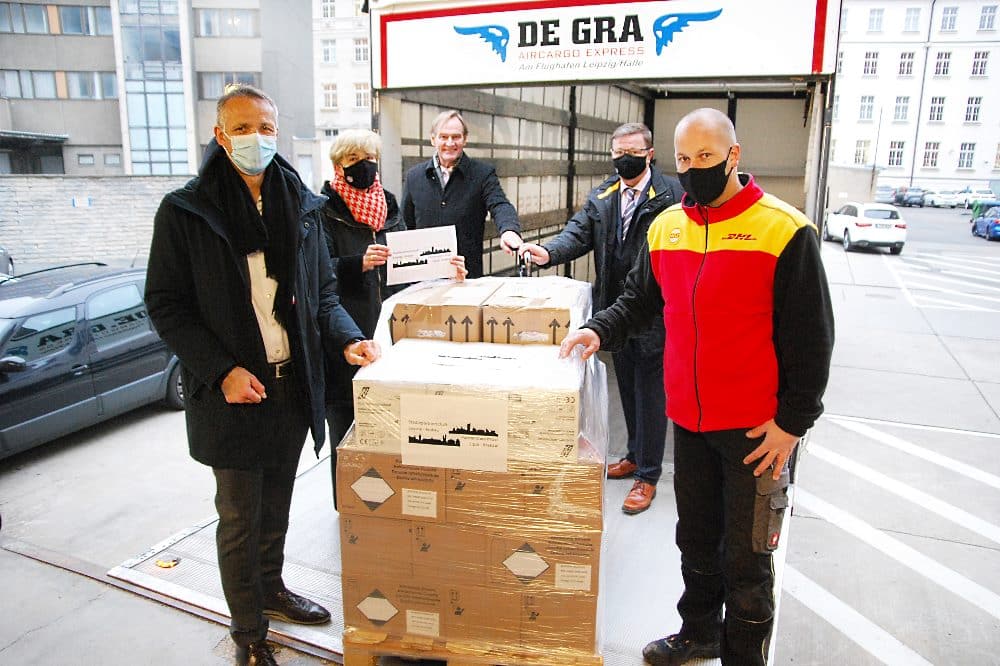 Ralph Wondrak, Geschäftsführer des DHL Express Drehkreuz, Dr. Gabriele Goldfuß, Leiterin des Referates für Internationale Zusammenarbeit, OBM Burkhard Jung, Andreas Kynast, Leitender Sicherheitsingenieur beim ASID und DHL-Fahrer Maik Platzeck (v. l.) mit der Maskenlieferung für Krakau. Quelle: Stadt Leipzig/sf