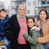 Halla Al-Saadi freut sich mit drei ihrer fünf Kinder über ihr neues Zuhause bei Vonovia. © Vonovia SE/Anika Dollmeyer