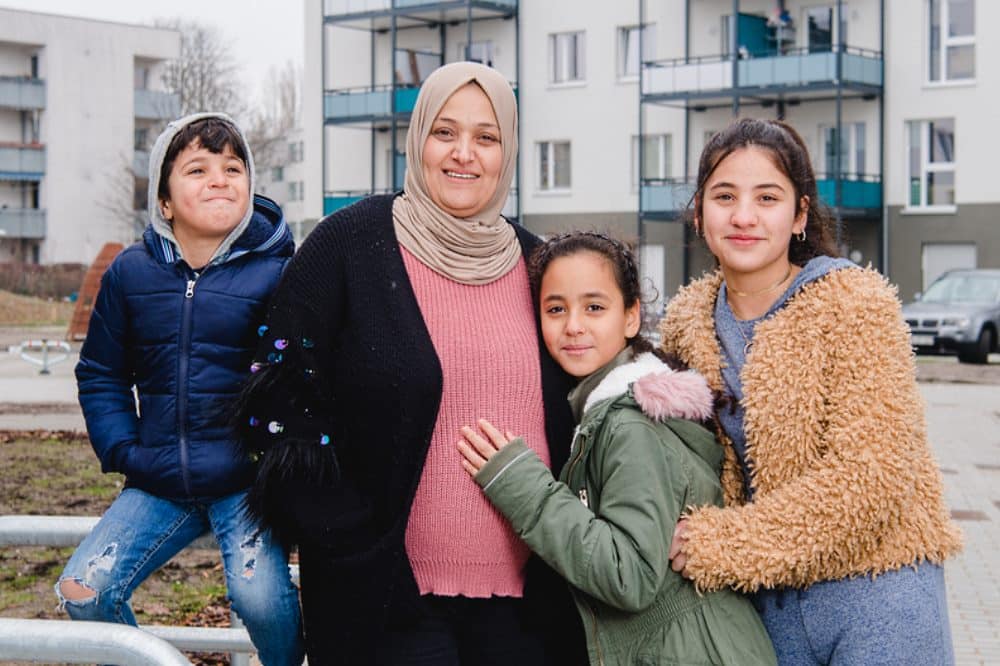 Halla Al-Saadi freut sich mit drei ihrer fünf Kinder über ihr neues Zuhause bei Vonovia. © Vonovia SE/Anika Dollmeyer