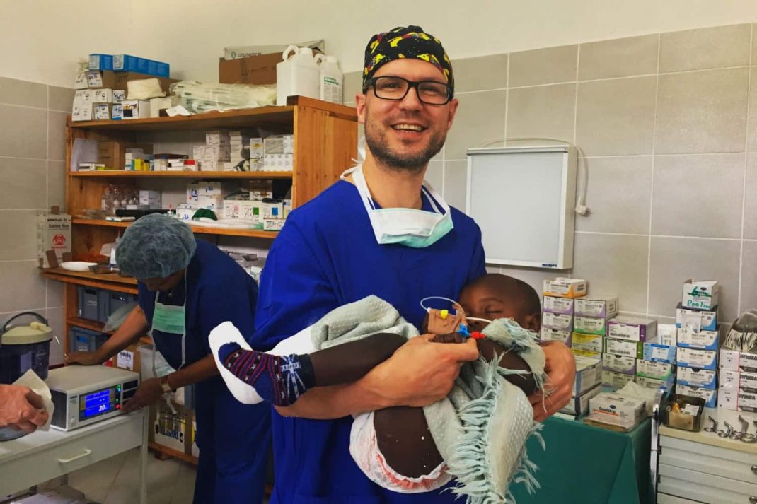 Prof. Martin Lacher mit einem operierten Kind auf dem Weg in den Aufwachraum. Foto: Stiftung Kinderchirurgie