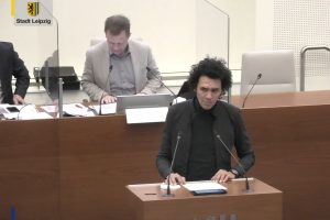 Mohamed Okasha stellt den Antrag des Migrantenbeirats zum Listenverfahren vor. Foto: Videostream der Stadt Leipzig, Screenshot: LZ