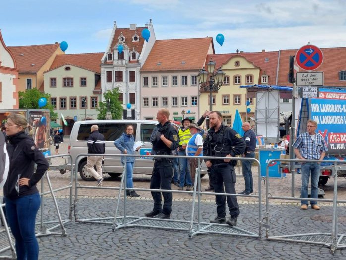 Polizeibeamte bewachen am Samstag ein Absperrgitter in Grimma, das die AfD-Kundgebung vom Gegenprotest trennt. Foto: LZ