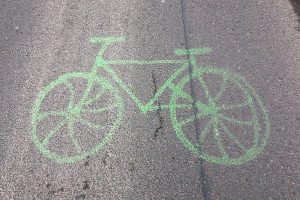 Grünes Radsymbol auf Asphalt.