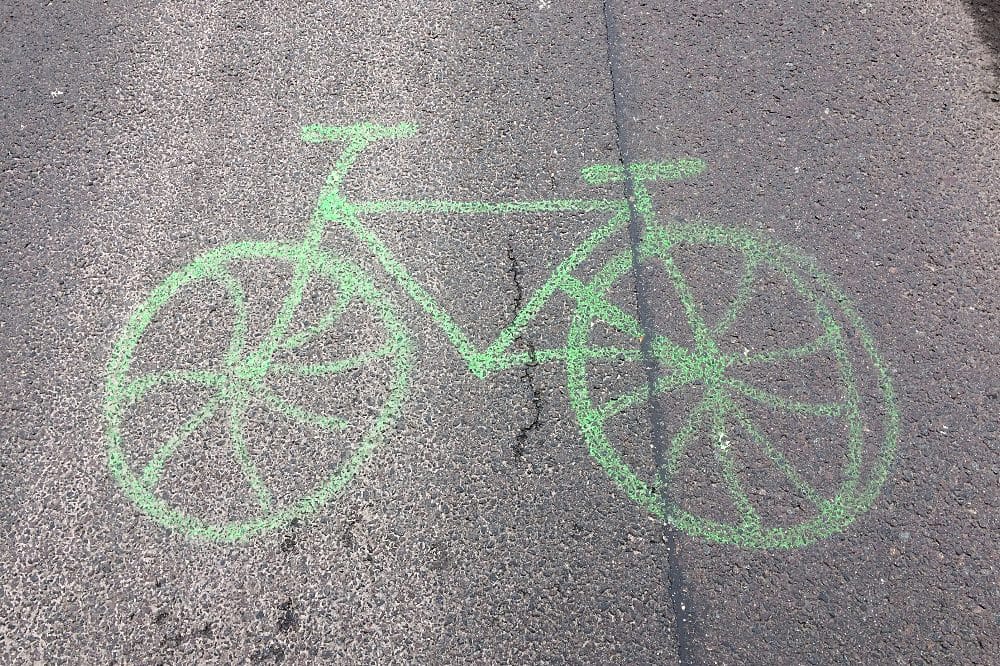 Grünes Radsymbol auf Asphalt.
