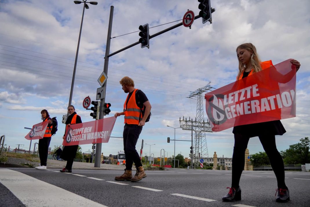Aktivist/-innen vom "Aufstand der letzten Generation" blockierten am heutigen Dienstagmorgen die Fahrbahn auf der Brandenburger Brücke. Foto: Gregor Wünsch