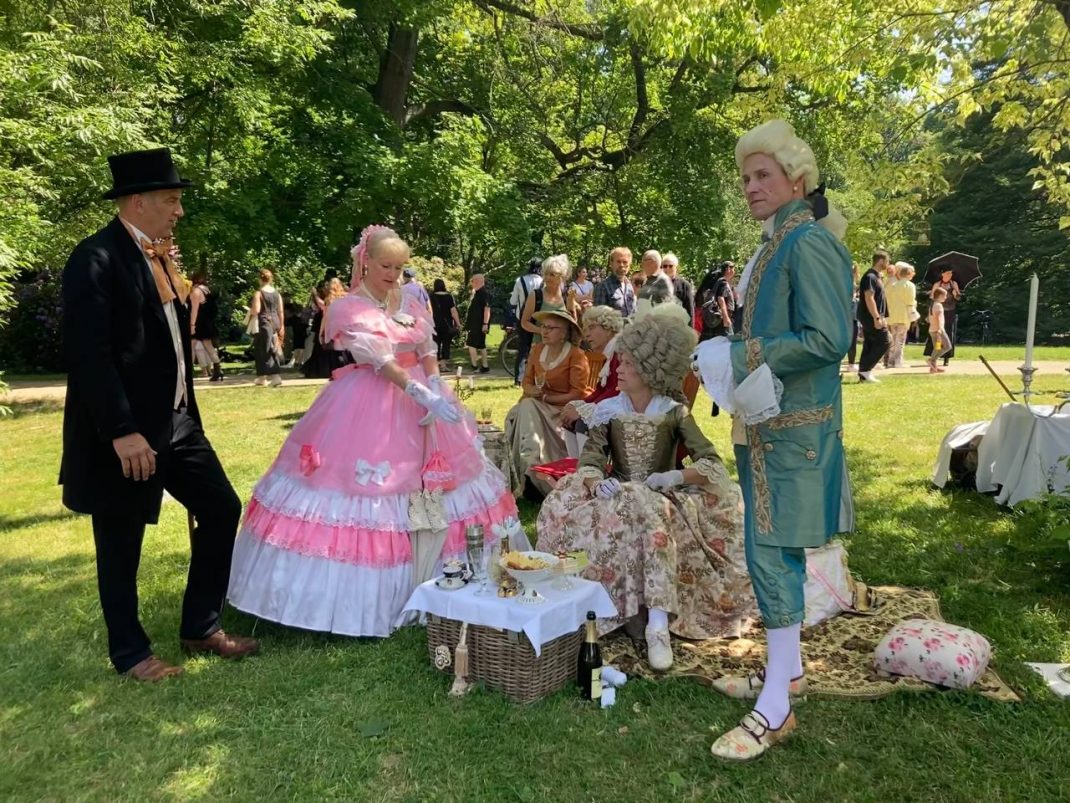Gruppe von Menschen beim WGT auf einer Parkwiese.