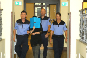 Angela B. (33) wird in Handfesseln durch Justizbeamte zum Gerichtssaal gebracht. Foto: Lucas Böhme
