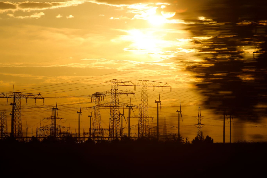 Sonnenuntergang über einer Landschaft aus Stromleitungen. Foto: Michael Freitag
