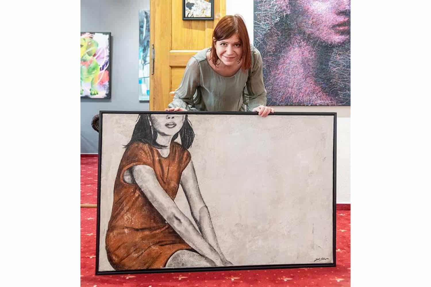 Galeristin Susanne Höhne mit einem Kunstwerk von Juli Schupa. Foto: Beuteltier Art Galerie