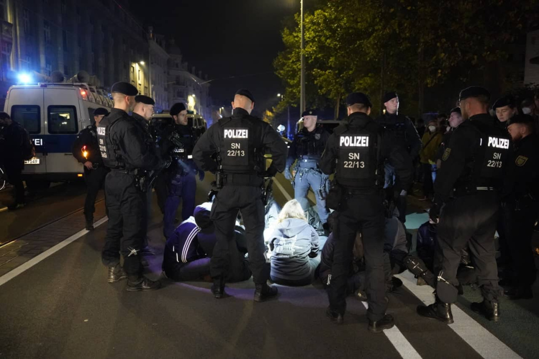 Polizisten umringen Sitzblockade.