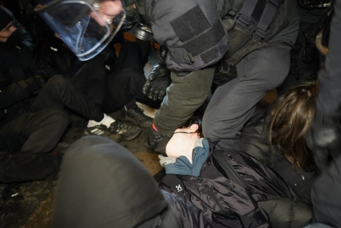 Die Polizei räumt eine Straßenblockade mit körperlichem Zwang und Schmerzgriffen