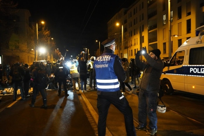 Eine Person gibt eine Interview vor einer Sitzblockade.