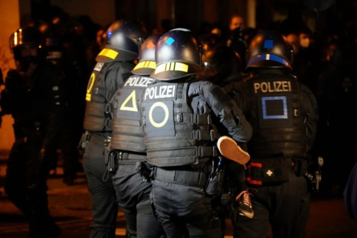 Die Polizei räumt eine Straßenblockade mit körperlichem Zwang und Schmerzgriffen.