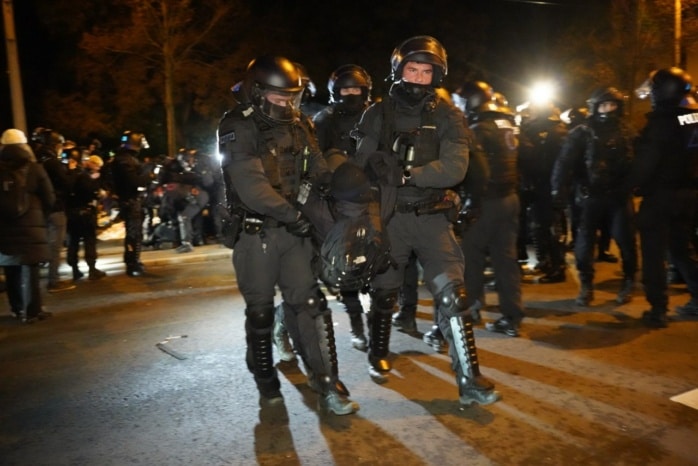 Die Polizei räumt eine Straßenblockade mit körperlichem Zwang und Schmerzgriffen