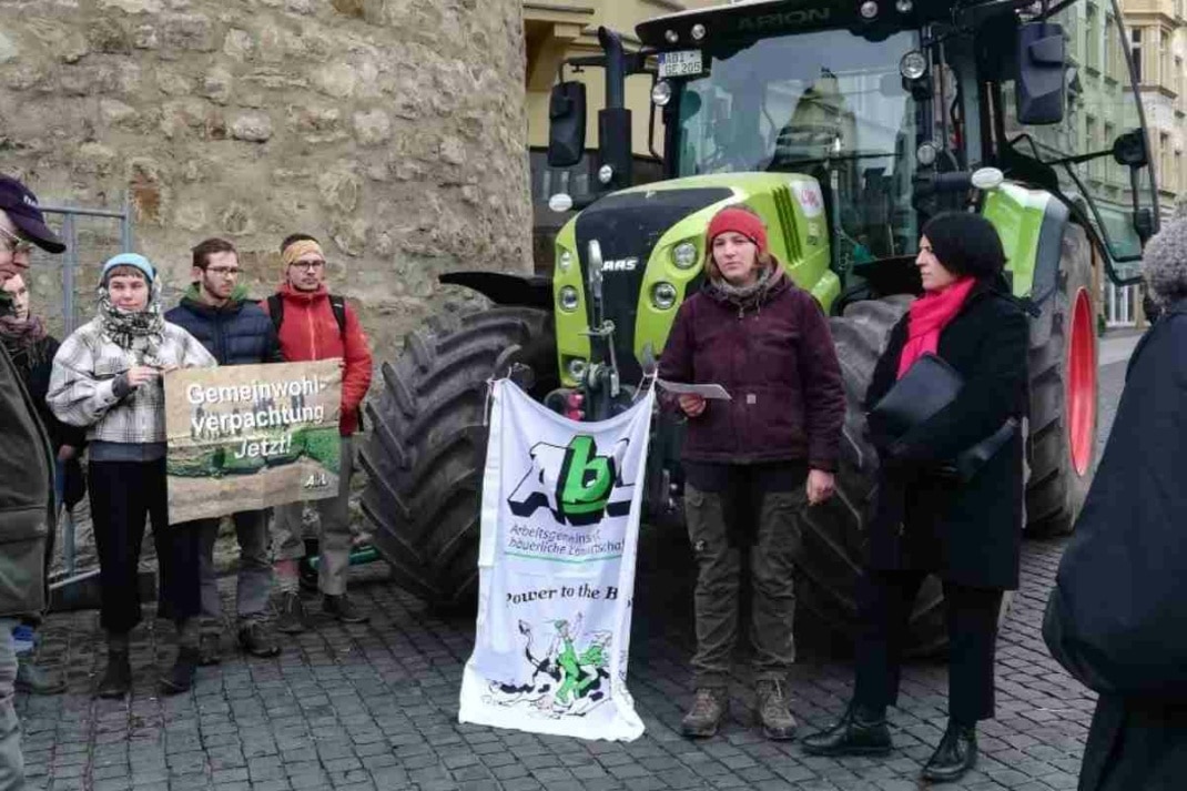 Protestierende mit Bannern vor einem Trecker