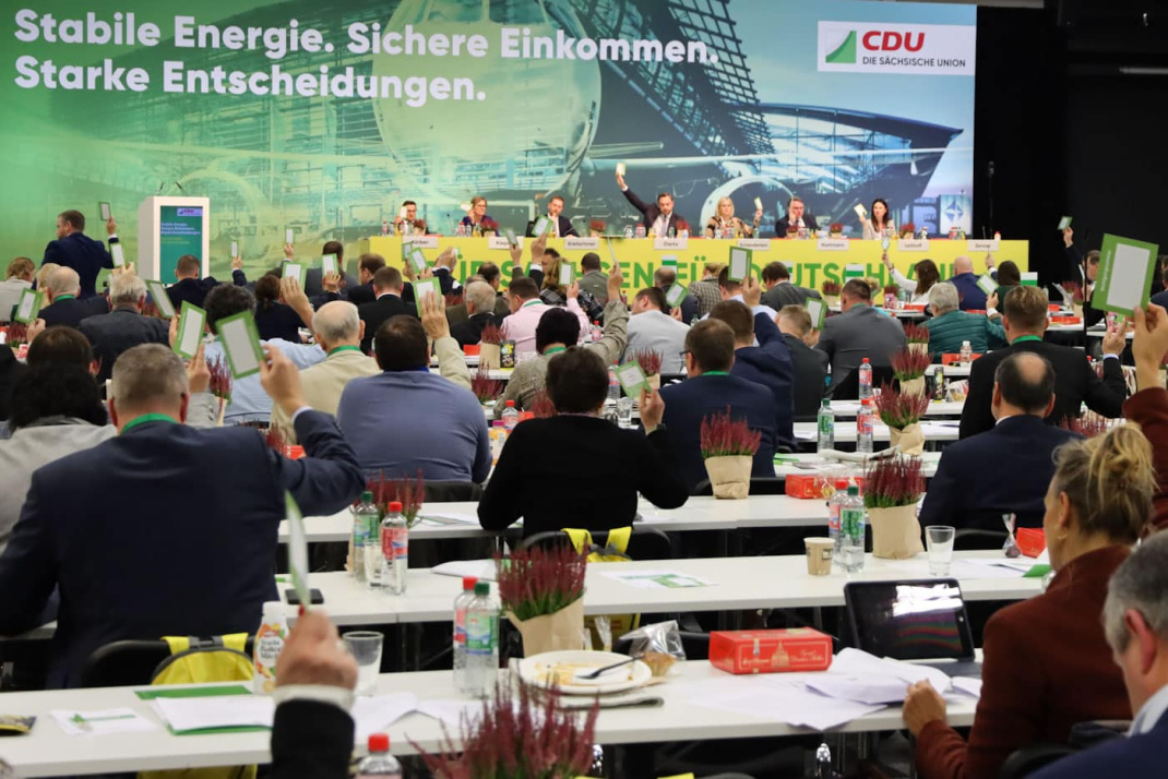 Die Delegierten des Landesparteitags der CDU-Sachsen stimmen ab. Dazu halten sie grün-weiße Kärtchen hoch, während sie an ihren Tischen im Tagungssaal sitzen.