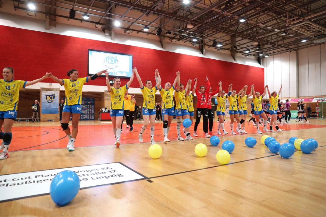 Das Team des HC Leipzig steht in einer Reihe vor der Tribüne und jubelt zusammen mit den Fans. Foto: Jan Kaefer