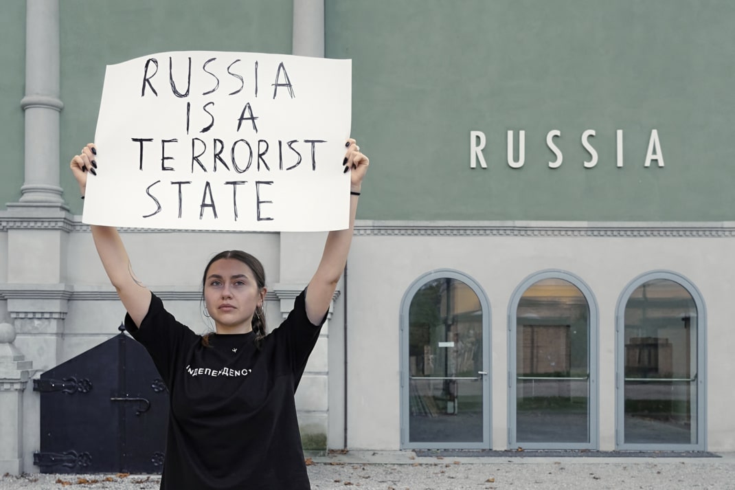 Die Leipziger Studentin und Ukrainerin Anna Perepechai hält vor dem russischen Pavillon auf der Venedig-Biennale 2022 ein Schild mit der Aufschrift "Russia is a terrorist state" in die Höhe.
