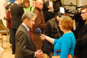 Mann wird mit Mikrofon interviewt.