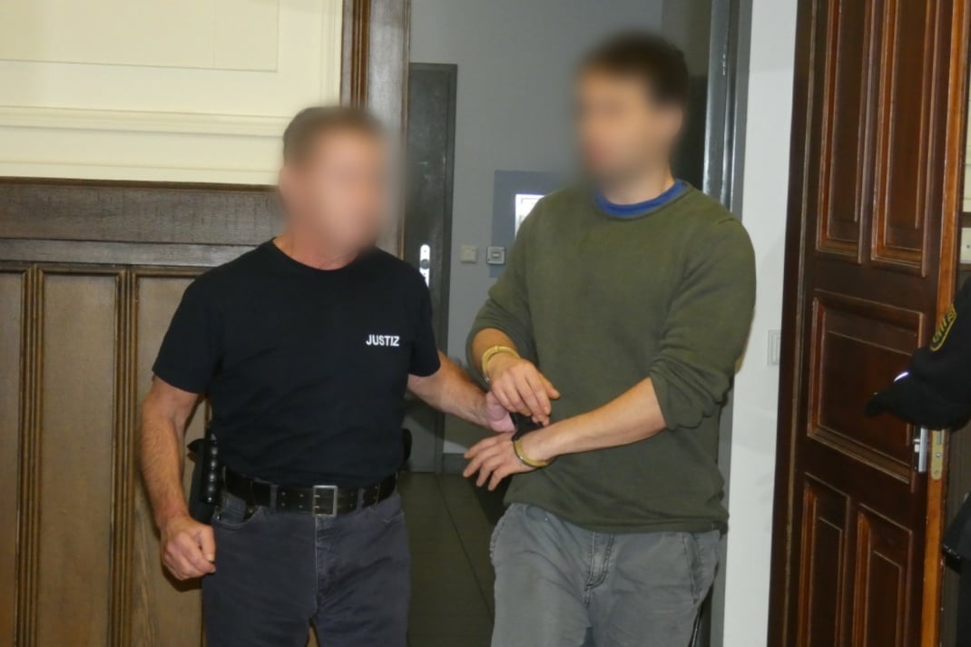 Der Angeklagte wird in den Gerichtssaal gebracht.
