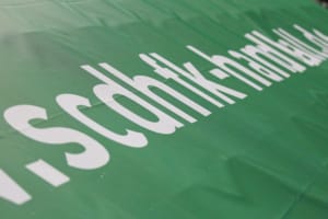 Schriftzug "scdhfk-handball.de" in weiß auf einer großen grünen Fahne. Foto: Jan Kaefer