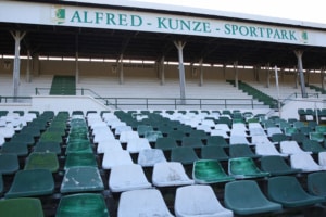 Blick auf die leere Tribüne des Alfred-Kunze-Sportparks mit grünen und weißen Schalensitzen. Foto: Jan Kaefer
