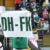 Ein Fan hält ein weißes Schild mit den grünen Buchstaben "DH-FK" hoch. Foto: Jan Kaefer